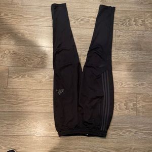 Black adidas soccer pants with gray tripes on the sides and zipper on bottom
